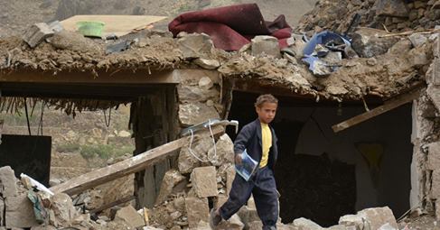 Yemen children walking on ruins